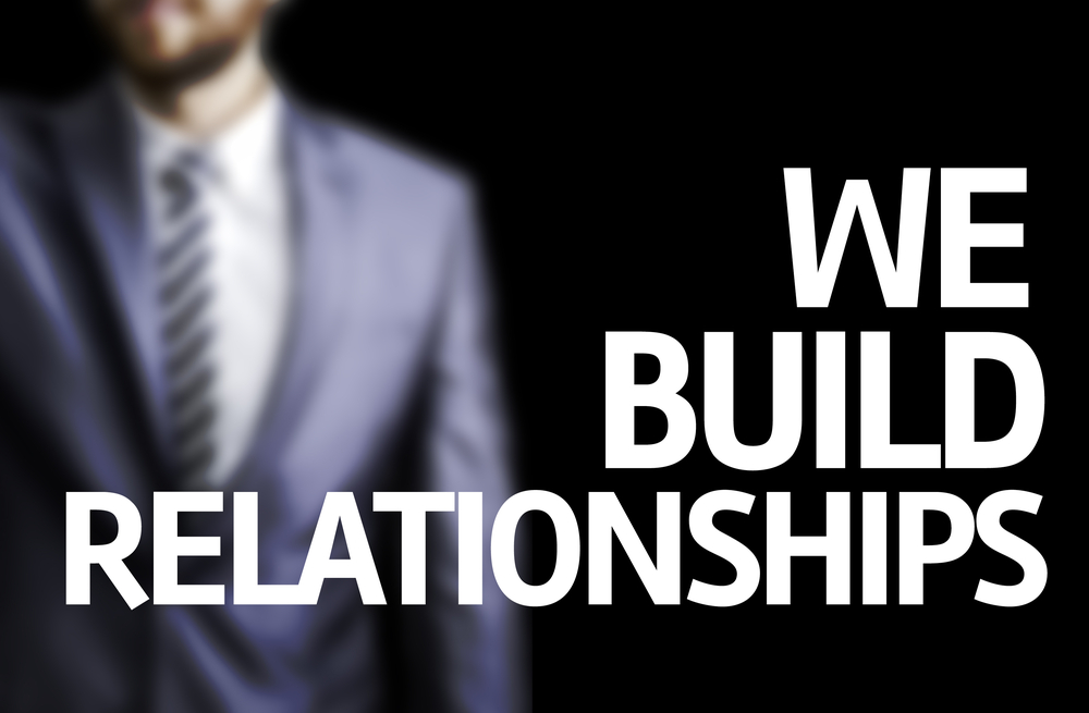 Image of person in a suit with text "We build relationships"