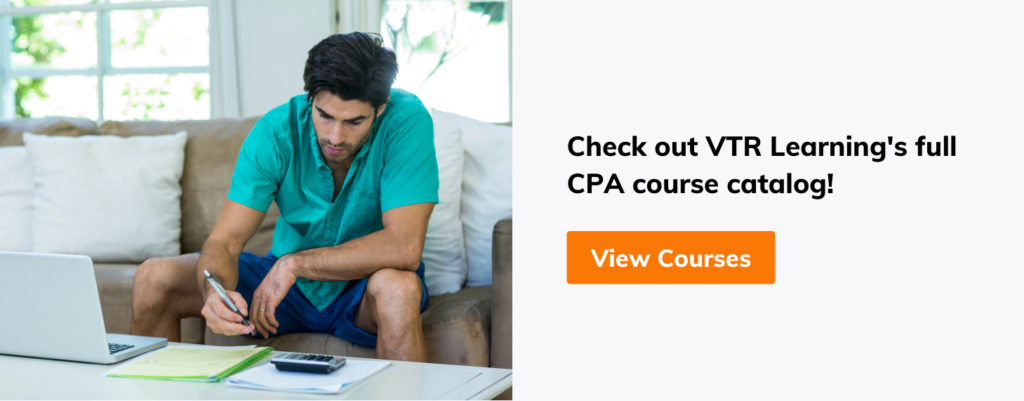 Man sitting on a couch, taking notes while working on a laptop computer