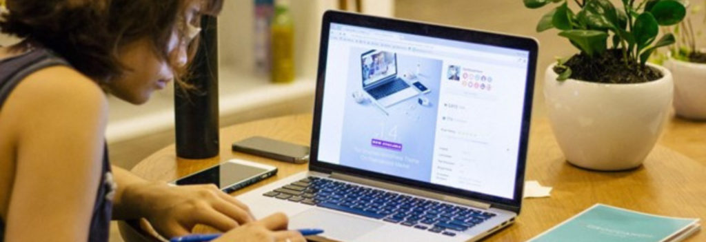 Woman creating a digital advertisement on a laptop