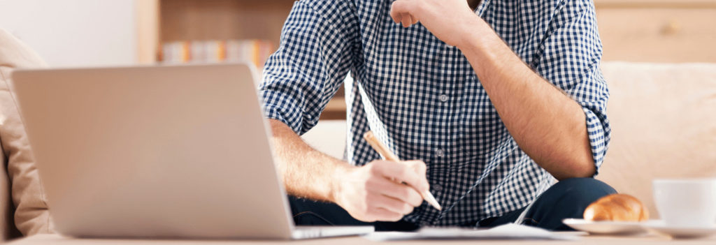 A man, trying to hone copywriting skills while writing on a paper